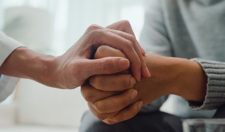 Close up of two hands holding, comforting.