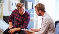 A male patient speaking with a GP.