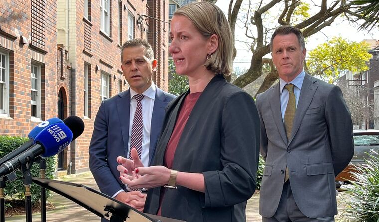 Woman with short blonde hair speaks to media.