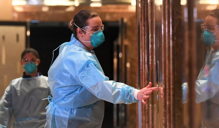 Healthcare worker in full PPE at hotel quarantine.