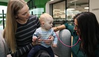 A women holding her baby next to a doctor.