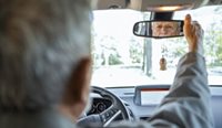 Elderly man looking in car