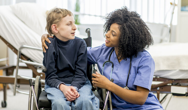Female doctor with young patient in wheelchair.