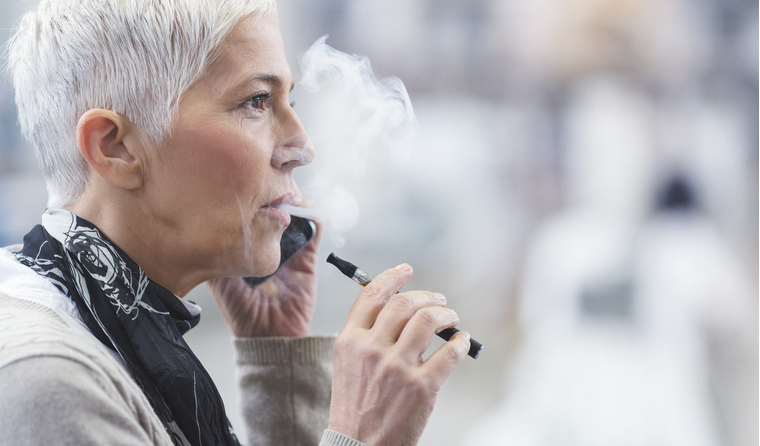 An older woman using an electronic cigarette.