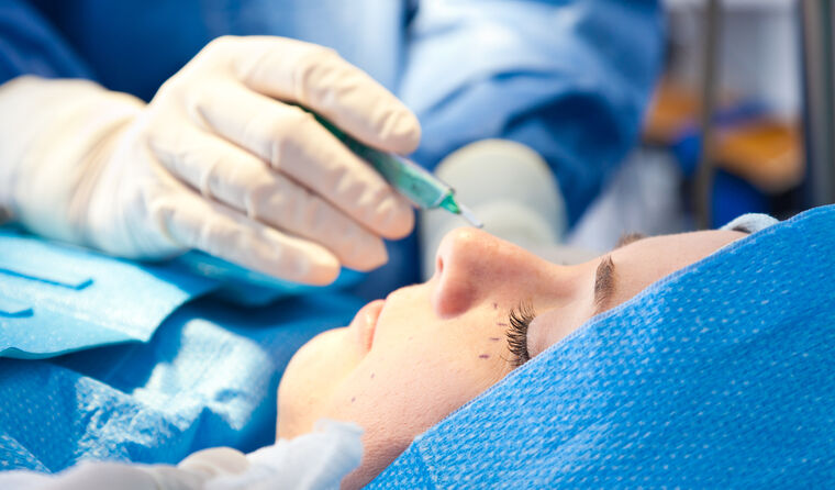 Surgeon performing surgery on a women.