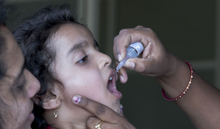 Child receiving oral polio vaccination.