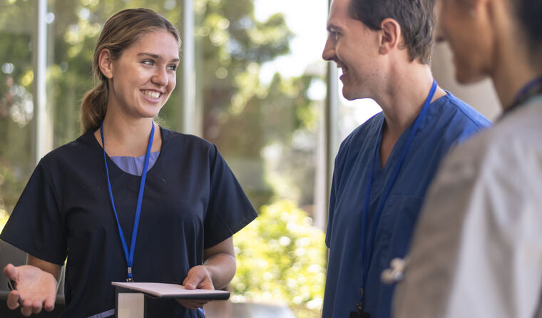 Smiling GPs talking in a group.