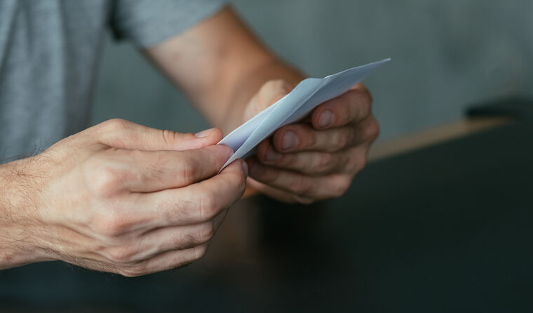 Male hands holding an opened letter.