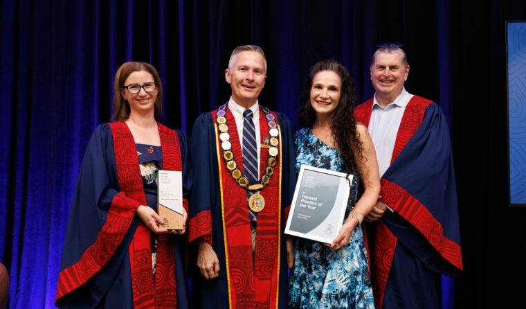 Four people on stage receiving awards
