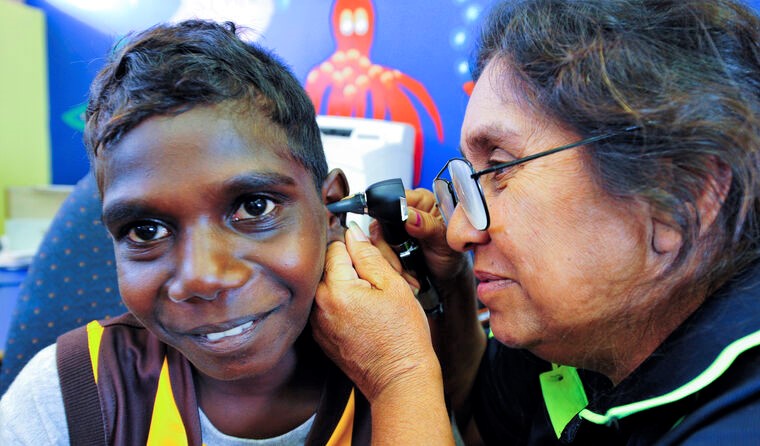 Doctor checking Aboriginal child's ear
