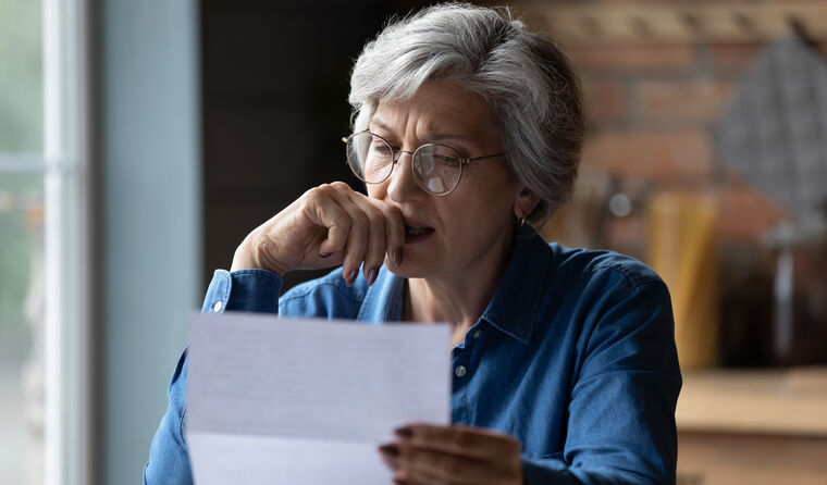 Concerned woman looking at letter 