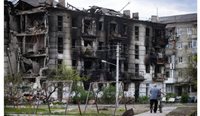 A local resident by an apartment block damaged by shellfire in the city of Rubezhnoye in Ukraine. (Picture: AAP Photos)