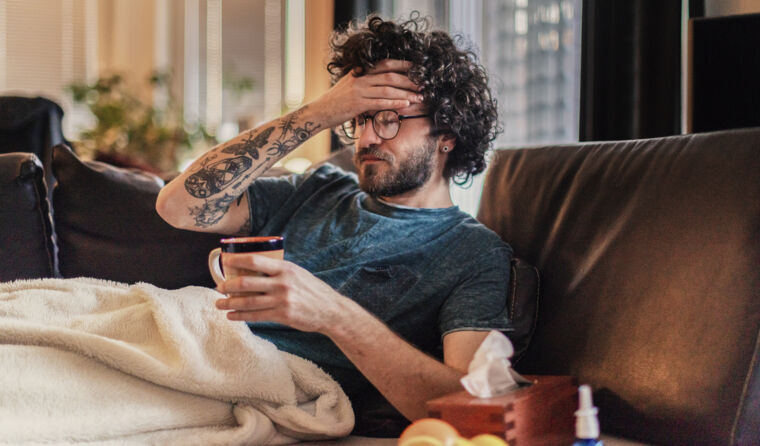 Man sick on the couch with flu.