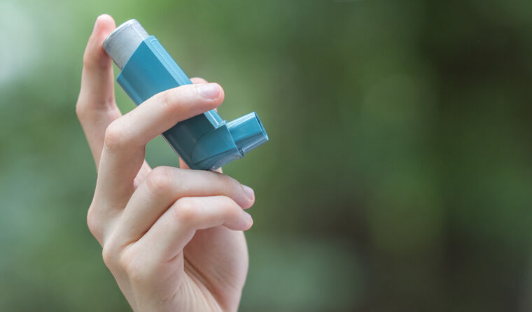 Person holding asthma inhaler