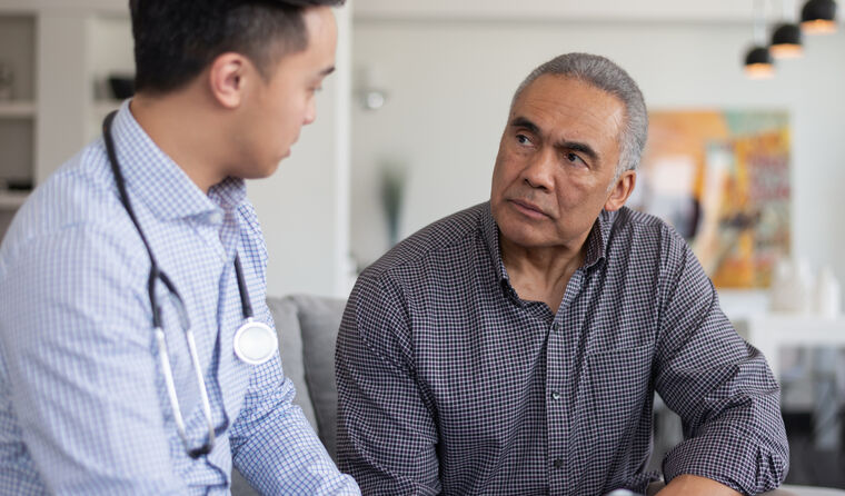 Male doctor with concerned older male patient.