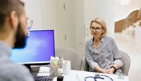 Female patient in consult, with computer visible