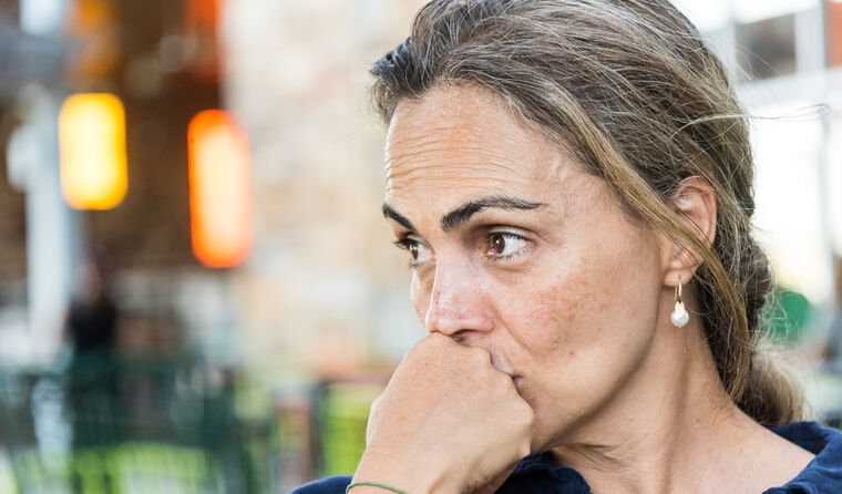 A middle-aged woman looking tense.