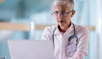 GP filling out survey on laptop