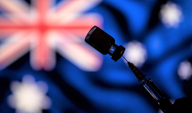 Vaccine vial in front of an Australian flag