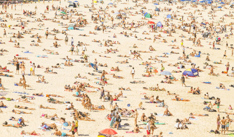 A beach full of people on the sand.