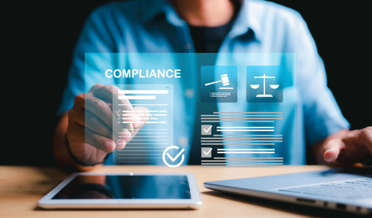 Person on computer with the word 'compliance'. 