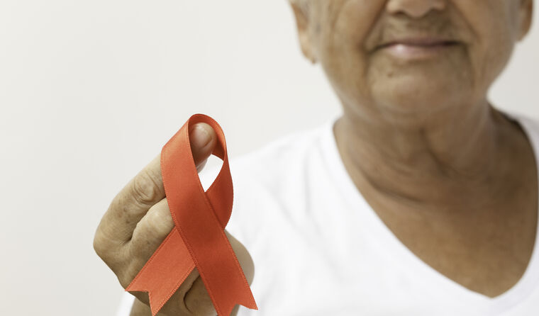 Older woman with red ribbon