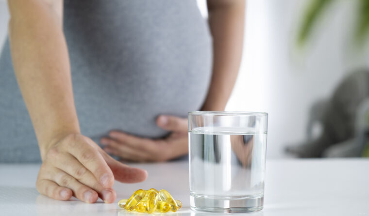 Pregnant person taking capsules