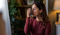 A woman uses an asthma inhaler.