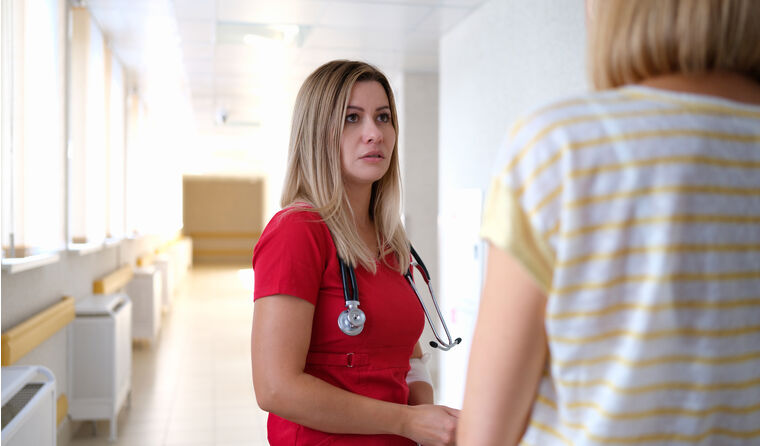 Doctor talking to colleague in the corridor.