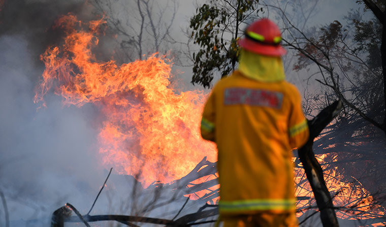 A firefighter attending to a bushfire. 