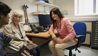 Older woman and young boy sit in office with GP