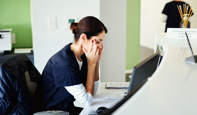 A medical receptionist looking stressed.