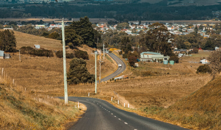 A long country road headed towards a town.