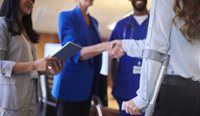 Woman with crutches shaking hands with doctor.