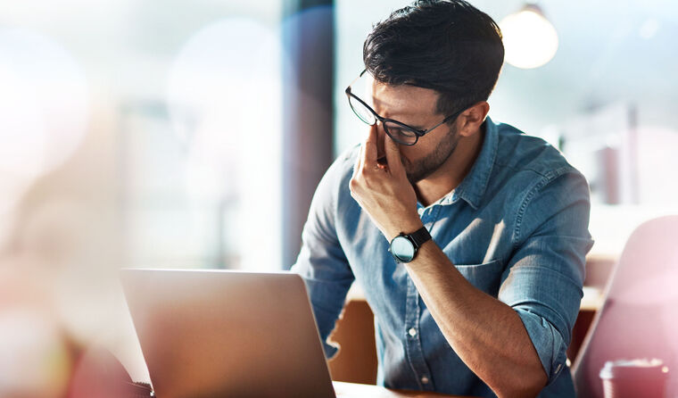 Man looking stressed at laptop