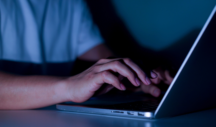 A man using a laptop at night.