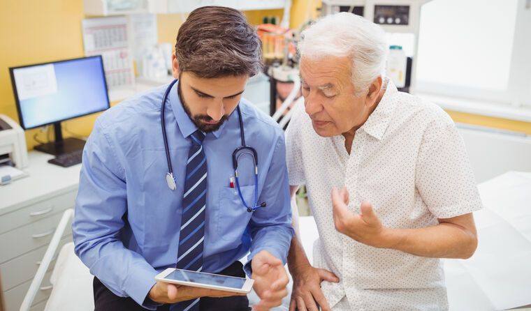 GP using a tablet to help a patient. 