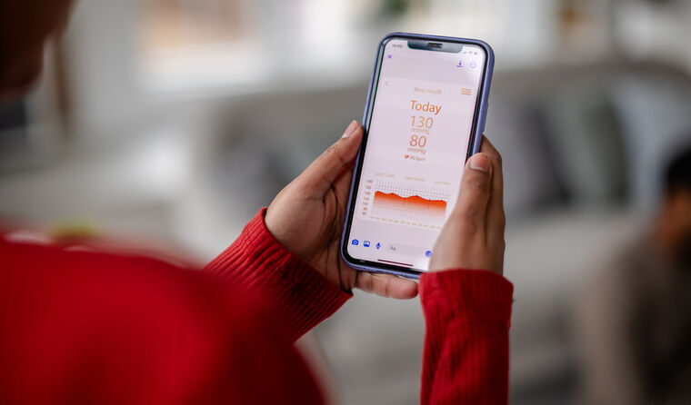A woman looks at a health app on her mobile phone.