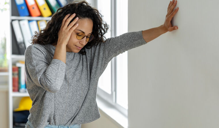 Young woman holding head and looking dizzy
