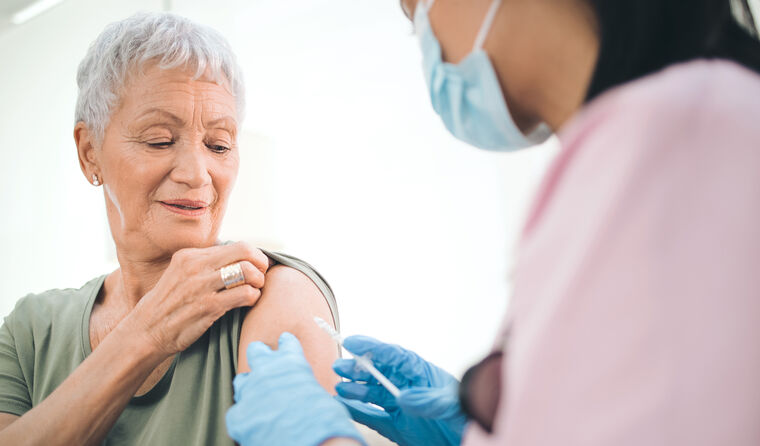 An elderly woman receives a vaccination