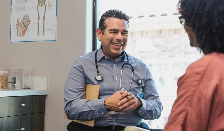 Male doctor smiles at patient.