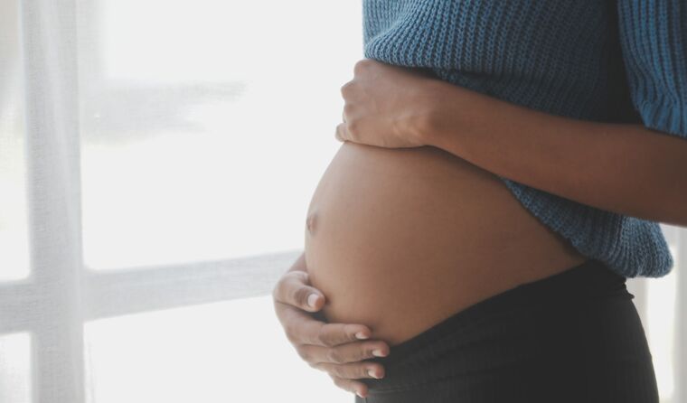 Side image of a woman's pregnant belly.