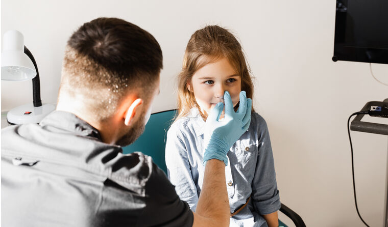 Child about to have intranasal vaccine with GP