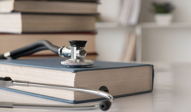 Stethoscope placed on top of medical text books.