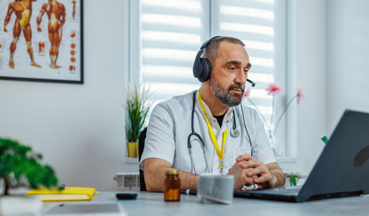 GP sitting at a computer.