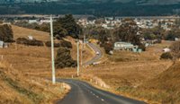 A long country road headed towards a town.