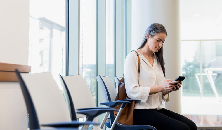 Patient in checking phone in clinic waiting room