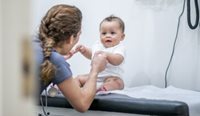 Female doctor holds little baby