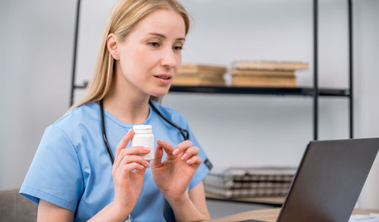 GP with pills container on a telehealth call